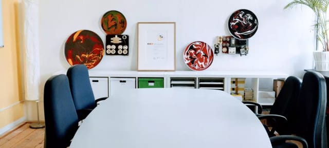 Modern meeting space in MACHWERK with round table, colorful art for collaboration.