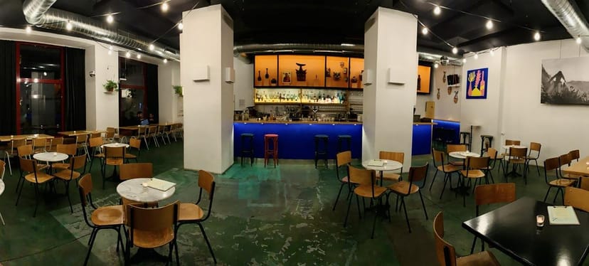 Outdoor bar with colorful lighting, ideal for casual meetings and events.