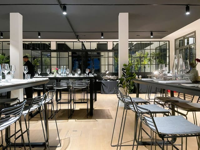 Elegant wintergarten event space with sleek tables, perfect for gatherings and celebrations.