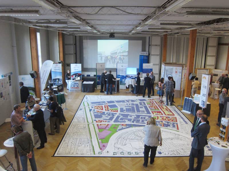 Function room in Turbinenhalle Berlin with exhibitors at a conference on urban development.