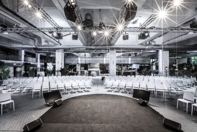 Function room in Tek Dream Event with central stage for conferences and presentations.