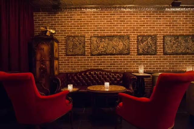 Intimate event space with plush red armchairs, ideal for networking or cocktail receptions.