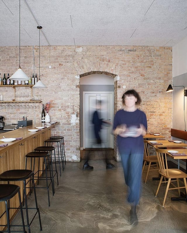 Modern restaurant bar with warm lighting, perfect for intimate dining and events.