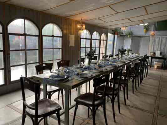 Elegant dining table with blue and white tableware in Freischwimmer Berlin's Fireplace Room.