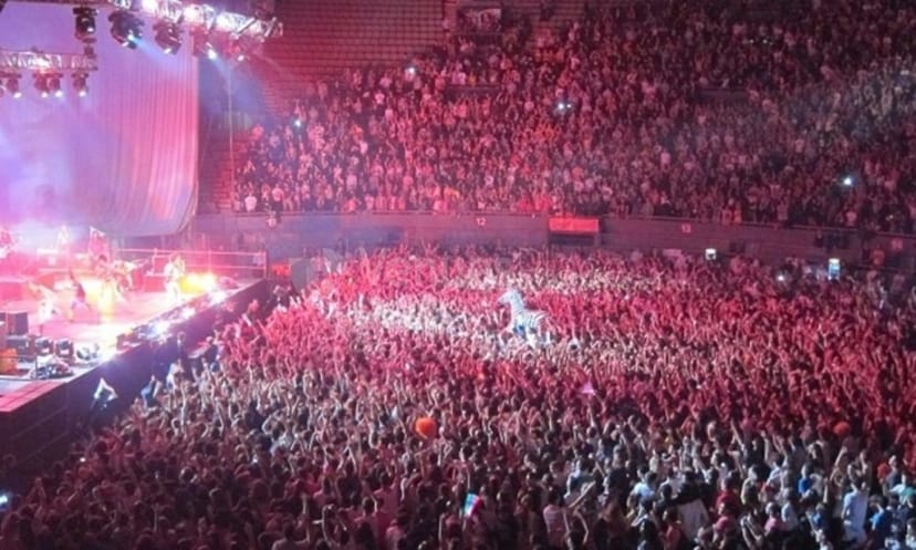 Packed Palacio Vistalegre Concert Hall with vibrant stage lighting at a large event.