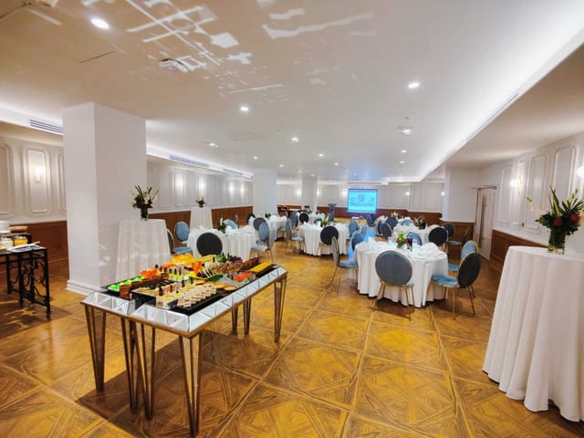 Elegant meeting space at Nishat Hotel, featuring round tables for corporate events.