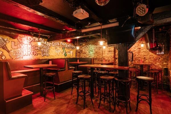 Intimate event space with exposed brick and cozy seating for workshops or live music.