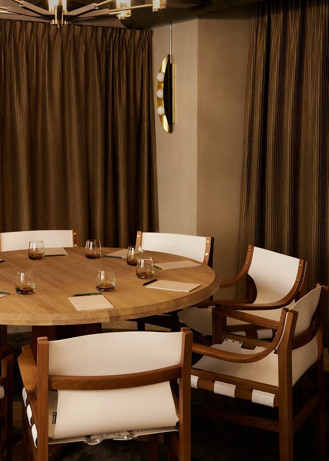 Sophisticated meeting room with round wooden table, ideal for networking and strategic planning.