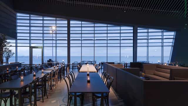 Modern dining area at Den Blå Planet with waterfront views for corporate events.