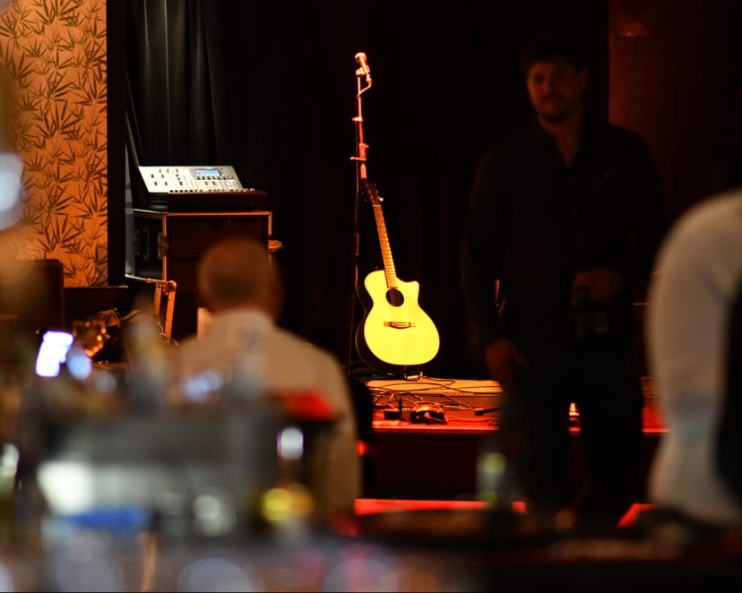 Live music bar stage at Lej Drop Inn with guitar, ideal for events and performances.