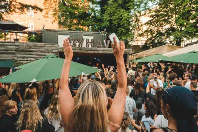 Vibrant outdoor event at Byhaven in Pumpehuset with engaged attendees and greenery.