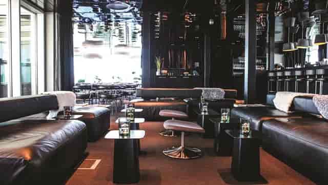 Contemporary lounge at Sushi Suiten with sleek black furnishings for networking events.