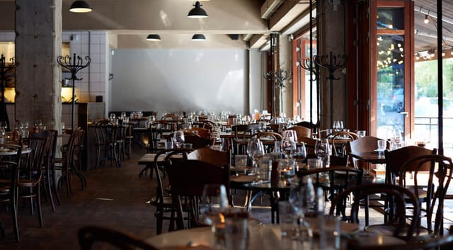 Spacious Restaurant Pluto venue with elegant tables, perfect for events and gatherings.