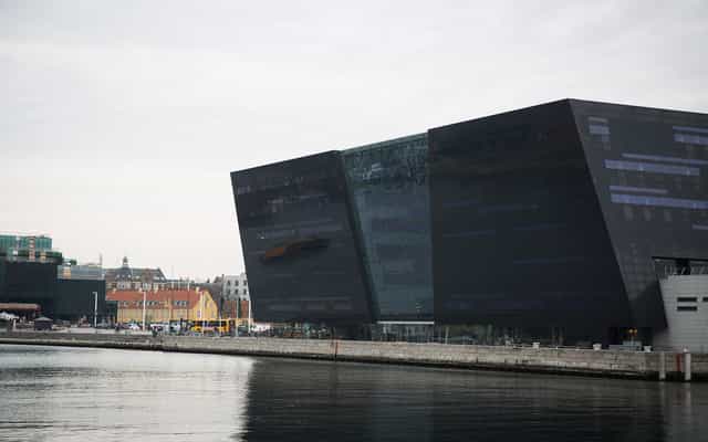 Modern angular building by waterfront, ideal for events and conferences.