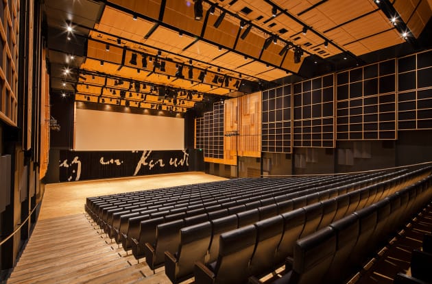 Modern Queen's Hall auditorium with tiered seating, perfect for conferences and presentations.