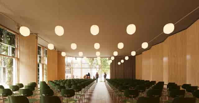 Modern event space at Royal Danish Academy of Music with green chairs and natural light.