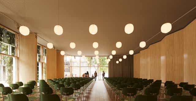 Modern event space at Royal Danish Academy of Music with green chairs and natural light.