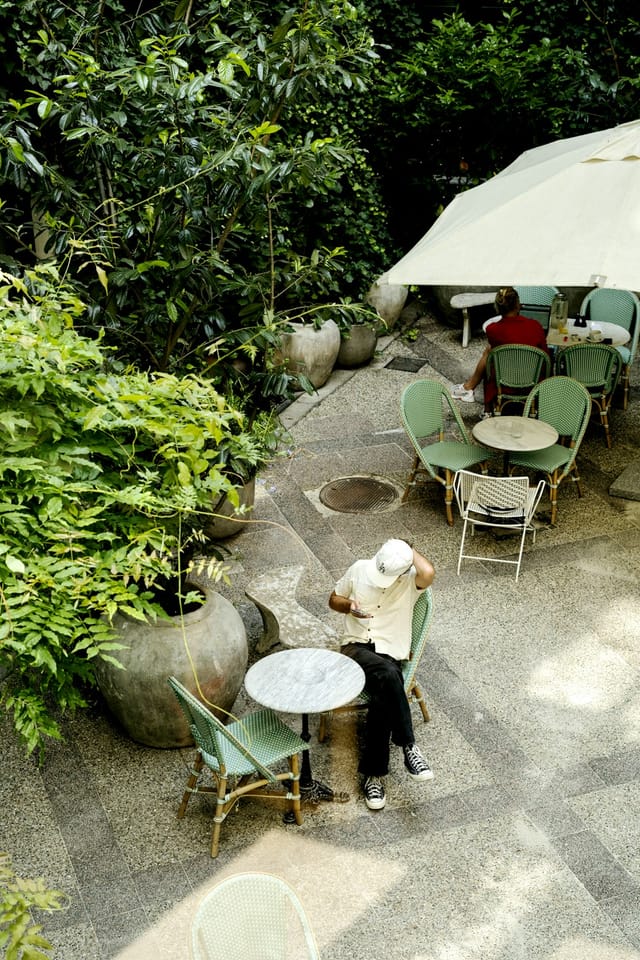 Coco Hotel courtyard with lush greenery, ideal for casual meetings and networking events.