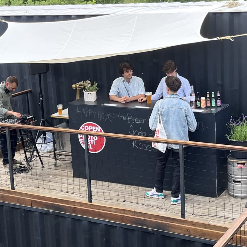 Vibrant outdoor bar at FRAME for networking events with live music and casual seating.