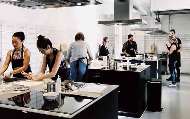 Dynamic cooking class in modern kitchen for corporate team-building events.