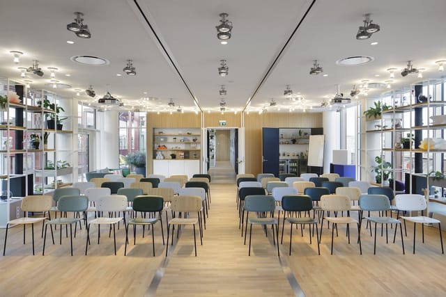 Modern conference room with multi-colored chairs, perfect for presentations and workshops.
