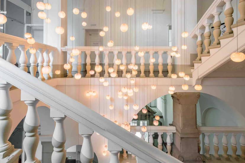 Elegant staircase with suspended lighting at Amtsalon Wilmina, perfect for events.