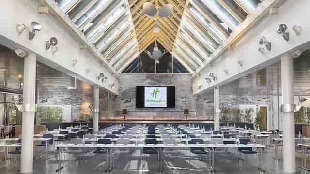 Spacious Holiday Inn meeting room with skylights for conferences and events.