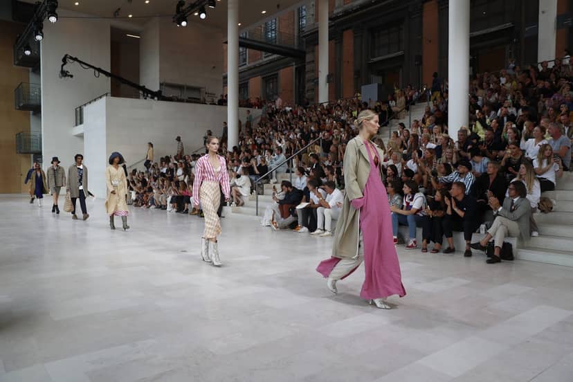 Fashion show at SMK Venue with runway, diverse models, and engaging audience.