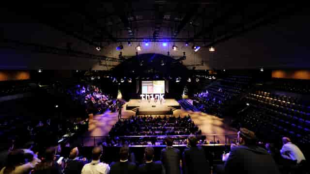 "Engaged audience at K.B. Hallen conference with staged multimedia presentation."