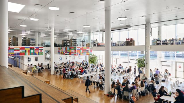 CIS Campus event space in Copenhagen, bright with diverse flags, perfect for meetings.