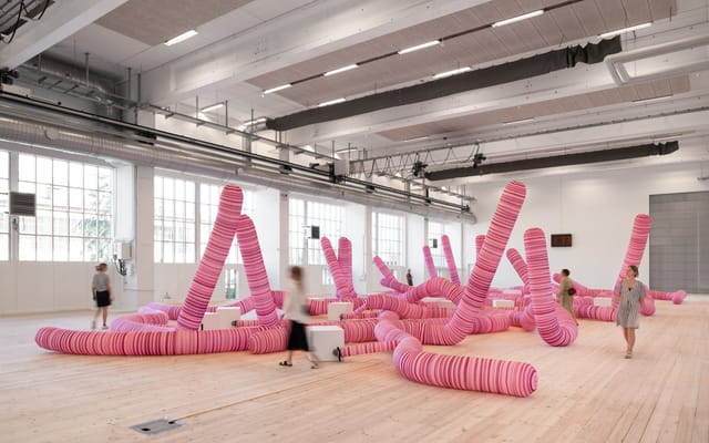 Interactive art installation in vibrant pink at Copenhagen Contemporary event space.