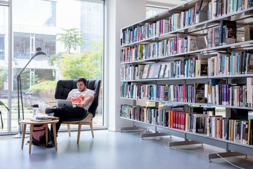 Modern library meeting room with cozy armchair in OIKOS, ideal for brainstorming and networking.