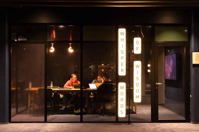 Modern meeting space "Whisper Words of Wisdom" with glass walls for collaboration.