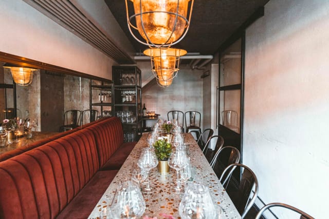 Elegant private dining room with long table, ideal for intimate dinners and corporate meetings.