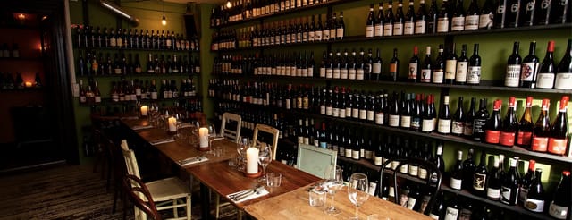 Cozy Bistro dining space with wine bottles, ideal for private events and wine tastings.