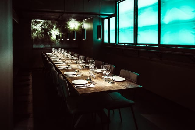 Elegant long dining table in Bibendum, ideal for intimate gatherings and corporate dinners.