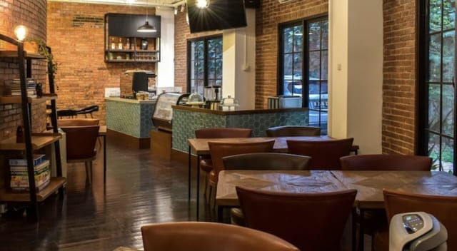 Cozy café in Rumanami Residence with exposed brick walls, ideal for networking events.