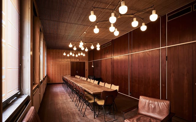 Spacious meeting room with wooden table, ideal for collaborative brainstorming sessions.