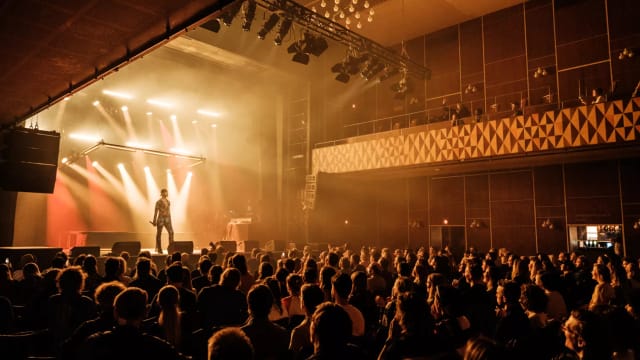 Ideal Bar in VEGA: packed auditorium with spotlight on performer, great for live events.