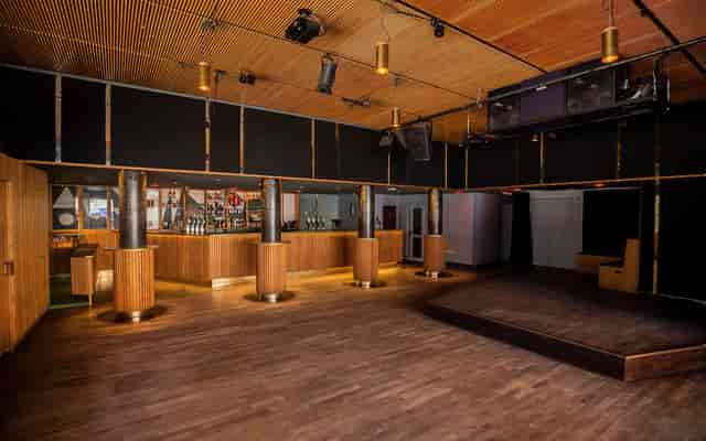 Spacious Ideal Bar venue with polished wood floor for corporate events and social parties.