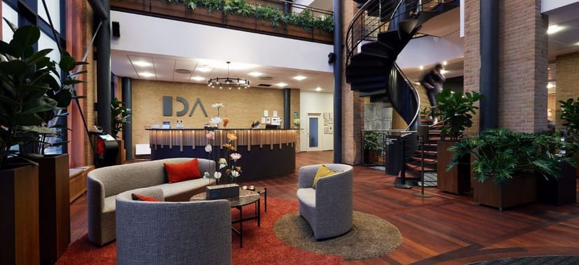 Modern reception area with spiral staircase at Selskabslokaler, ideal for conferences and events.