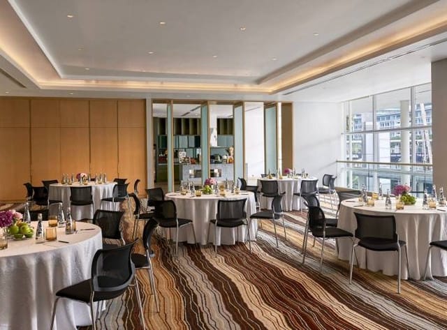 Elegant event space in Pullman Jakarta with round tables for networking and gatherings.