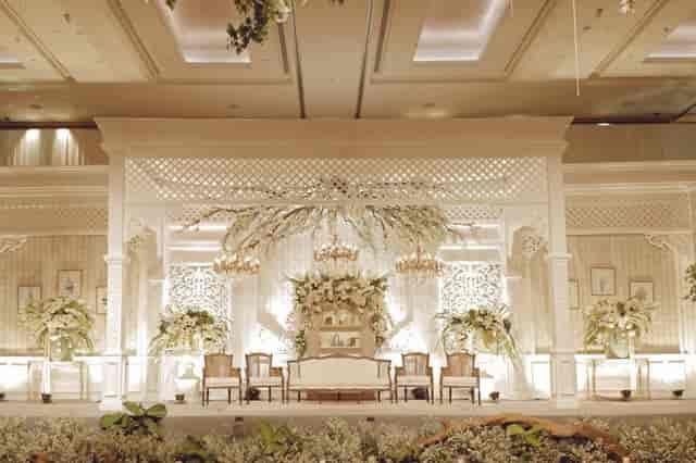 Elegant Grand Ballroom stage with floral backdrop, ideal for weddings and corporate events.