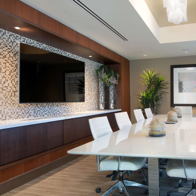 Modern boardroom with wall-mounted screen for effective meetings and collaboration.