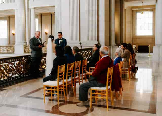 Intimate wedding ceremony in San Francisco's elegant Mayor's Office, romantic venue.