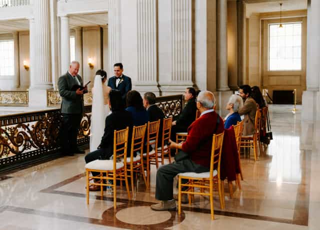 Intimate wedding ceremony in San Francisco's elegant Mayor's Office, romantic venue.