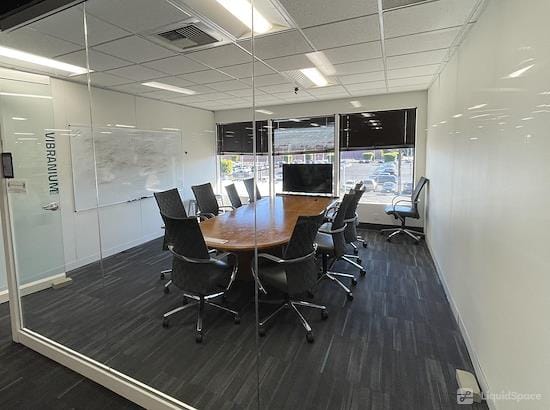 Modern private office with circular table, ideal for meetings and events.