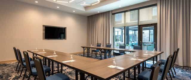 Conference room with U-shaped seating at Hilton Garden Inn Boston Canton for corporate events.