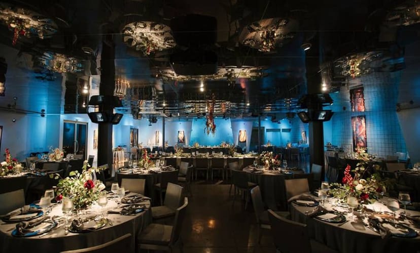 Elegant event venue with blue lighting and floral centerpieces for memorable celebrations.