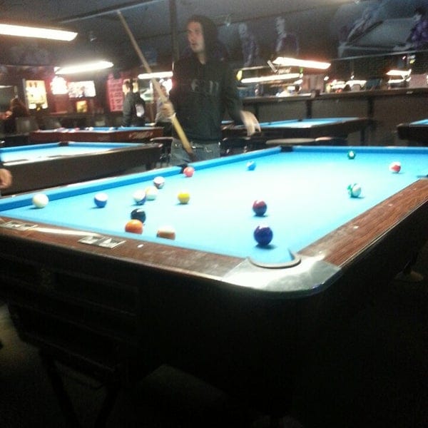 Pool hall at Mr. Lucky's Billiards, featuring a vibrant blue table for team bonding events.